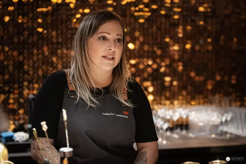 Professional Bartender in Black Uniform at Illuminated Bar Station