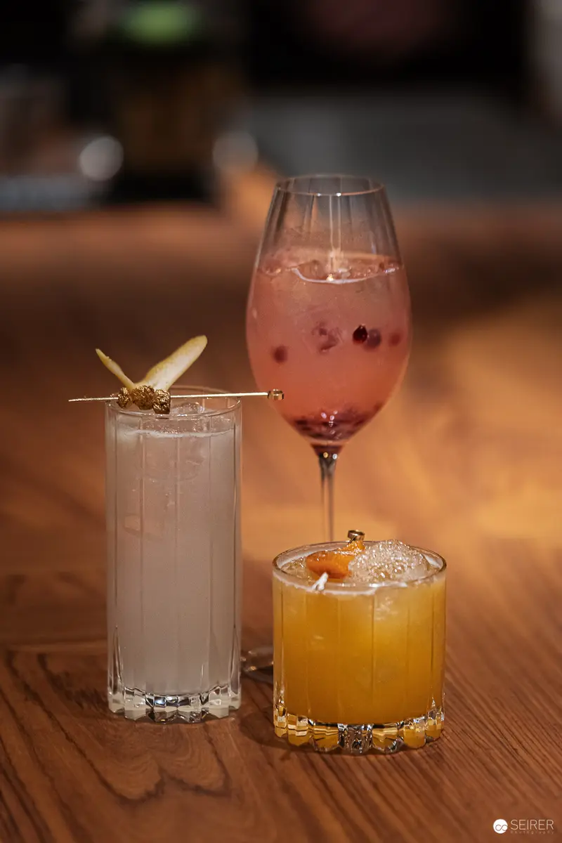 Artisanal Cocktail Composition with Multicolored Beverages and Decorative Garnish