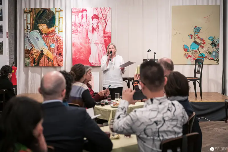 Art Gallery Talk: Speaker Presents amid Vibrant Figurative Paintings