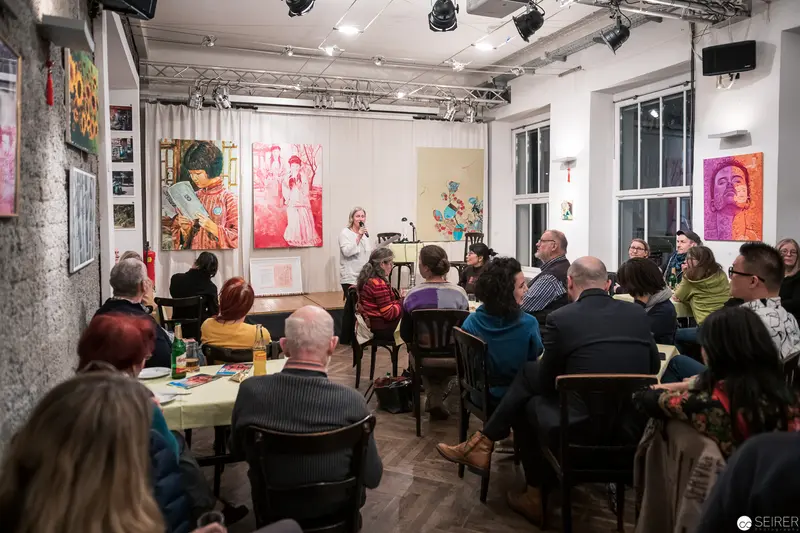 Art Gallery Talk with Colorful Portraits and Attentive Audience