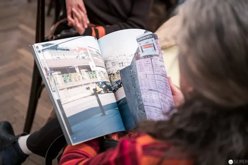 Reader Examining Photographic Book with Urban Landscape Spread