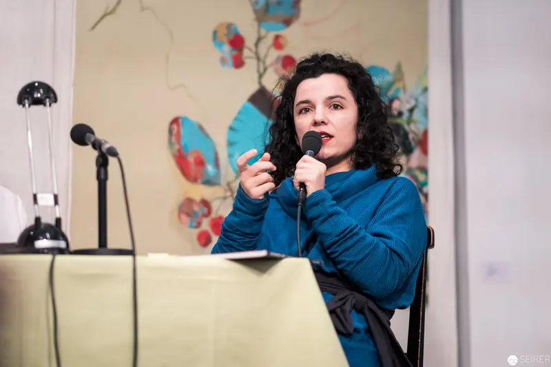 Performer in Blue Sweater Delivering Presentation with Microphones