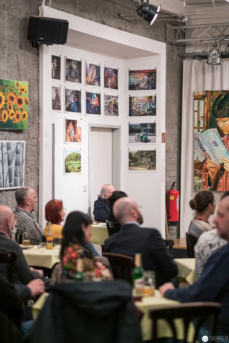 Community Art Exhibition with Diverse Photographic Display and Attentive Audience