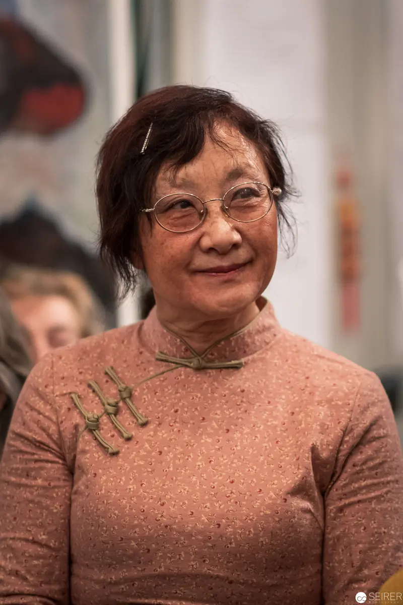 Mature Woman in Speckled Salmon Sweater Wearing Round Eyeglasses
