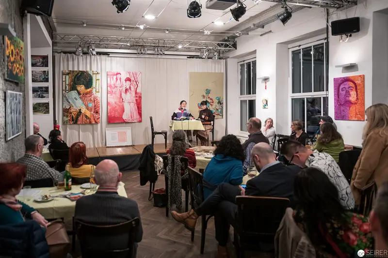 Community Art Event with Vibrant Portraiture and Engaged Audience in Gallery Space