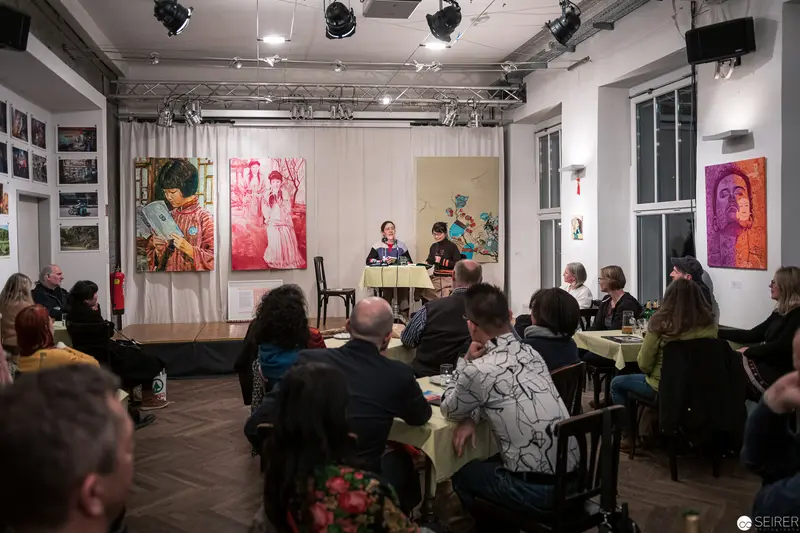 Art Gallery Panel Discussion with Vibrant Portraiture and Attentive Audience