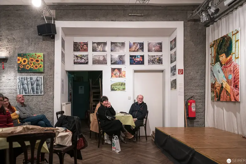 Gallery Interior with Photographic Exhibits and Visitors in Contemplative Moment