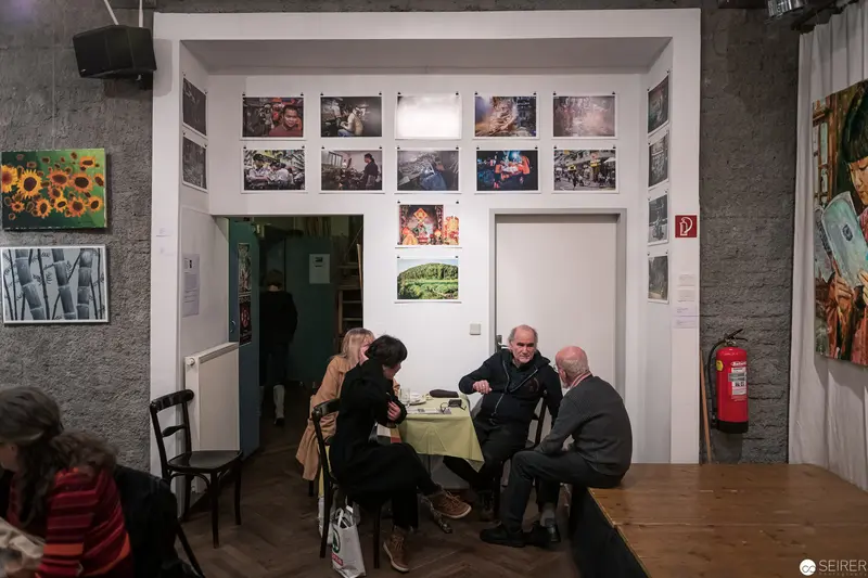 Gallery Interior with Seated Visitors Amid Photographic Exhibition Display