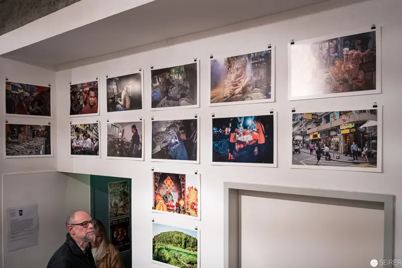 Photographic Exhibition Interior with Diverse Documentary Images and Viewer