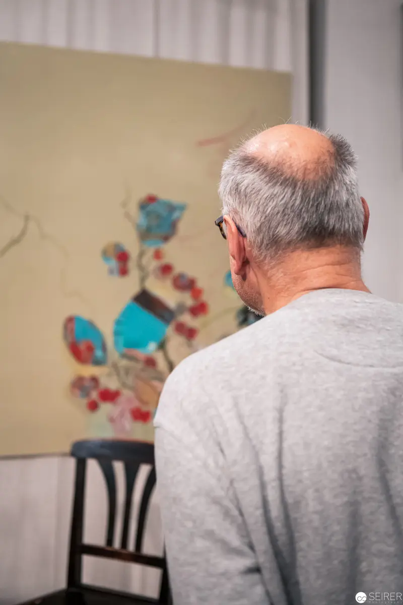Elderly Viewer Contemplating Abstract Wall Art in Quiet Reflection