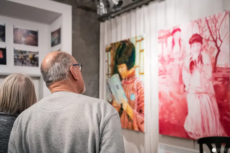 Art Gallery Visitors Viewing Monochromatic Red and Multicolor Portrait Exhibitions