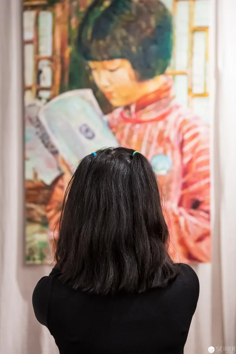 Viewer Contemplating Artwork of Young Reader in Museum Gallery