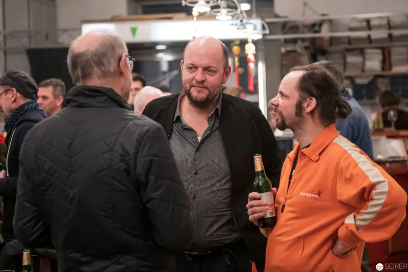 Industrial Workshop Social: Men Conversing During Informal Gathering with Beer