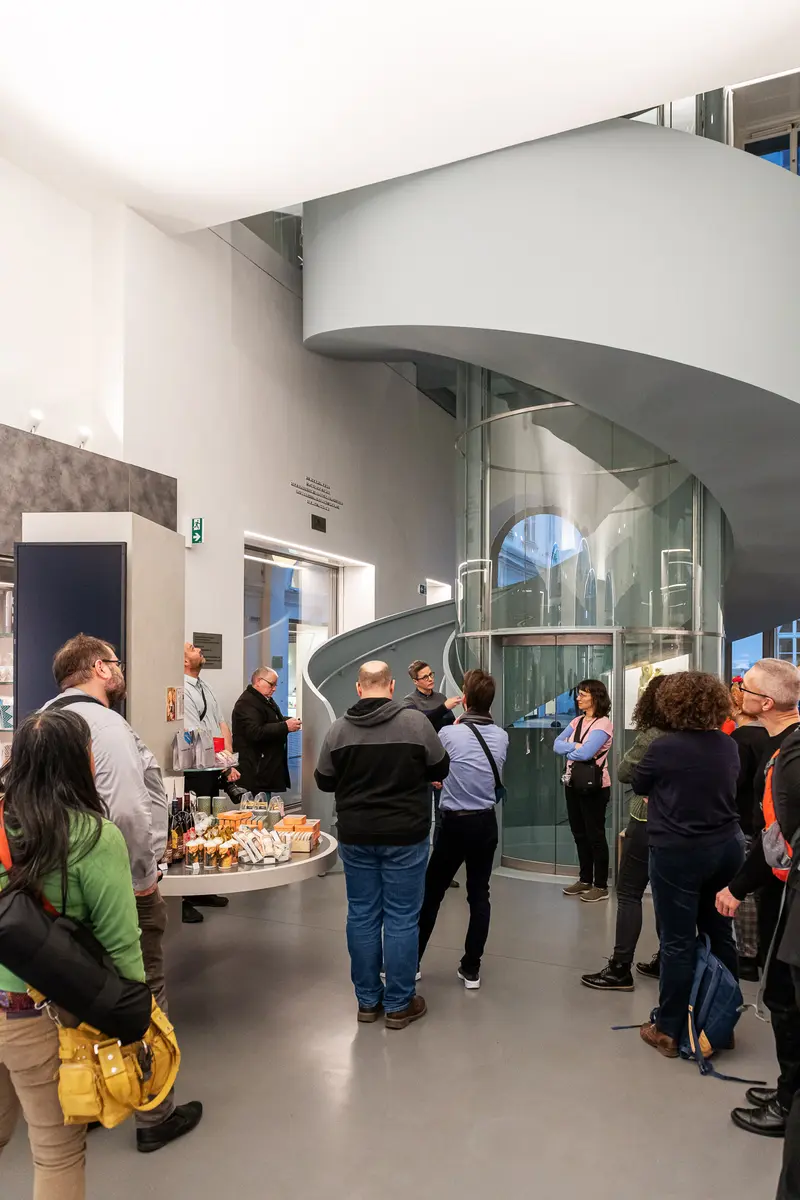 Visitors Navigating Curved Glass Stairwell at "Family Matters" Exhibition, Dom Museum Vienna