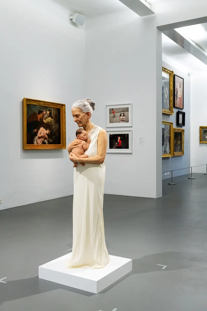 Maternal Contemplation in White Dress at "Family Matters" Exhibition, Dom Museum Vienna