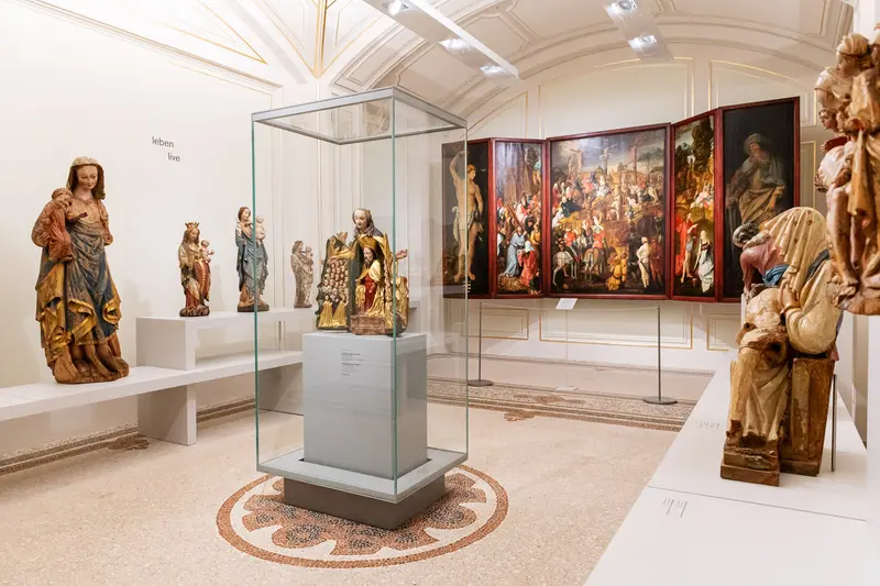 Medieval Religious Sculptures and Altarpiece in Museum Exhibition Space