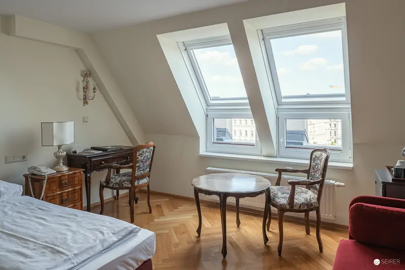 Serene Attic Hotel Room with Antique Furnishings and Dormer Windows
