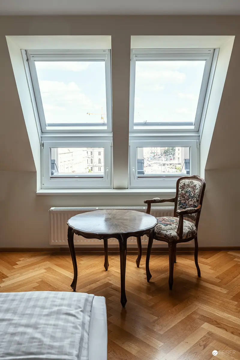 Serene Attic Room with Antique Furniture and Herringbone Parquet Flooring