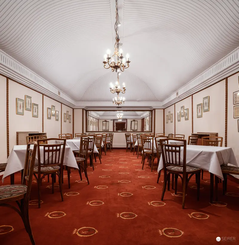 Elegant Dining Room at Hotel Regina with Ornate Chandelier and Red Carpet