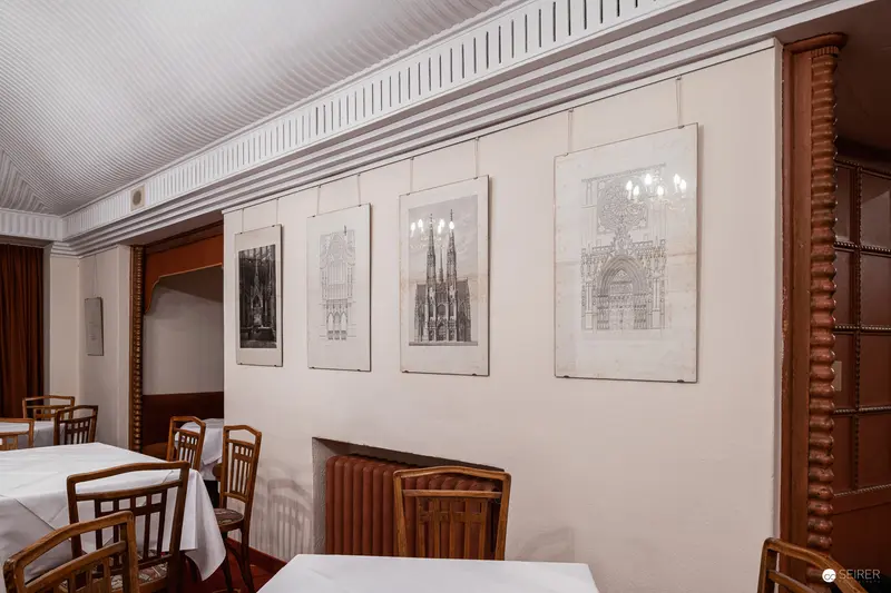 Architectural Drawings of Gothic Structures in Minimalist Dining Room Setting