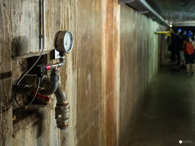Industrial Pressure Gauge in Dimly Lit Utility Corridor at Kraftwerk Freudenau
