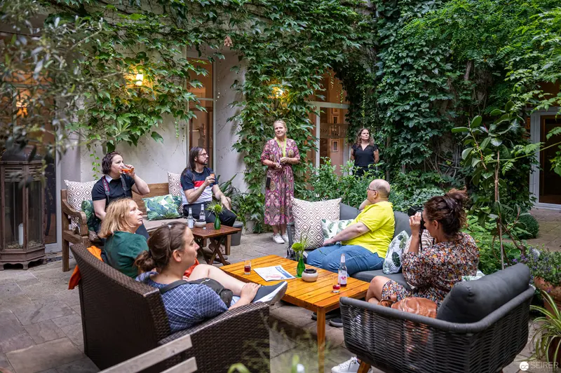 Group Gathering in Verdant Courtyard at Foto Reportage Boutiquehotel Stadthalle, Wien