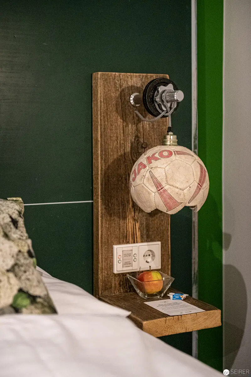 Wooden Wall Fixture with Soccer Ball and Apple in Green-Toned Interior