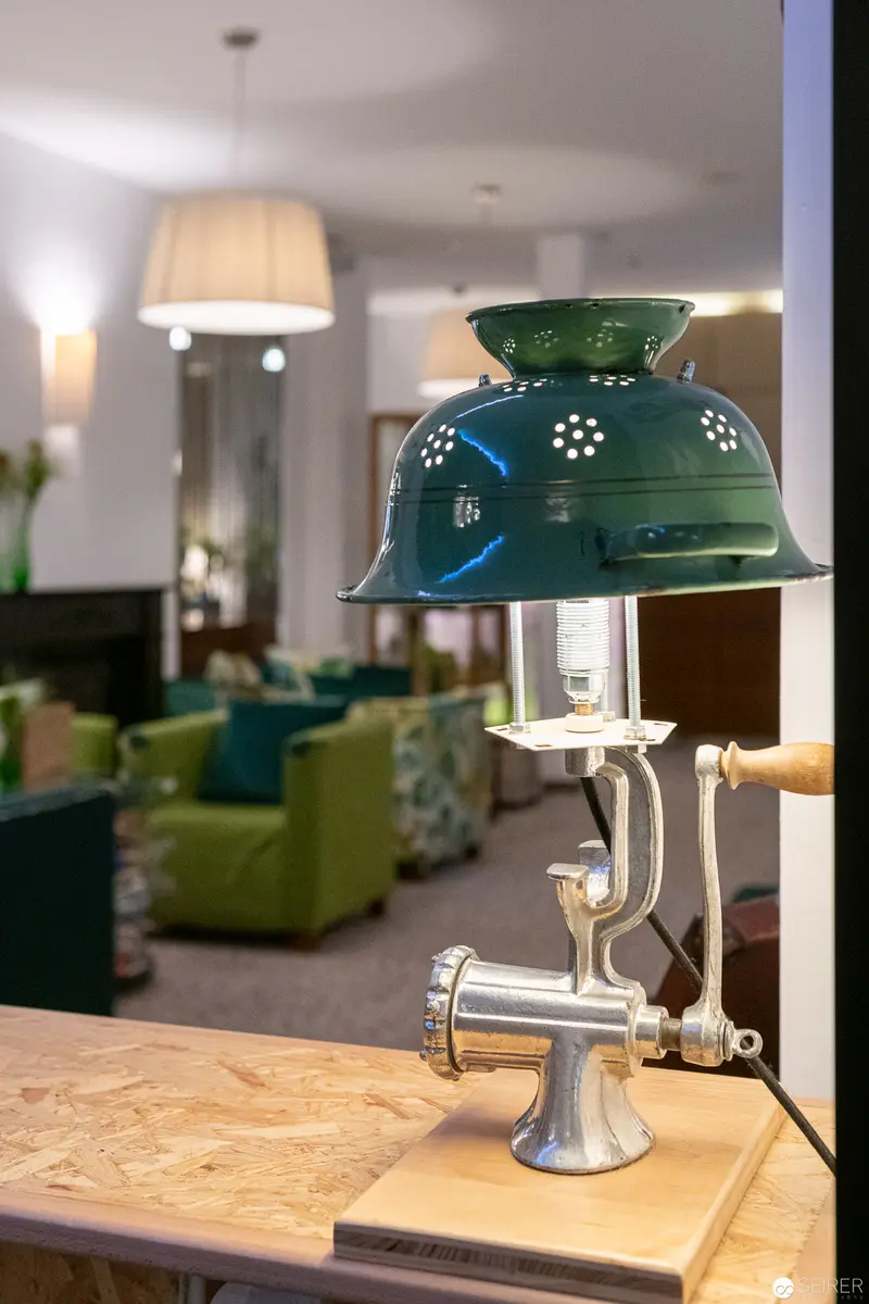 Vintage Green-Shaded Lamp on Wooden Surface at Stadthalle Hotel, Vienna