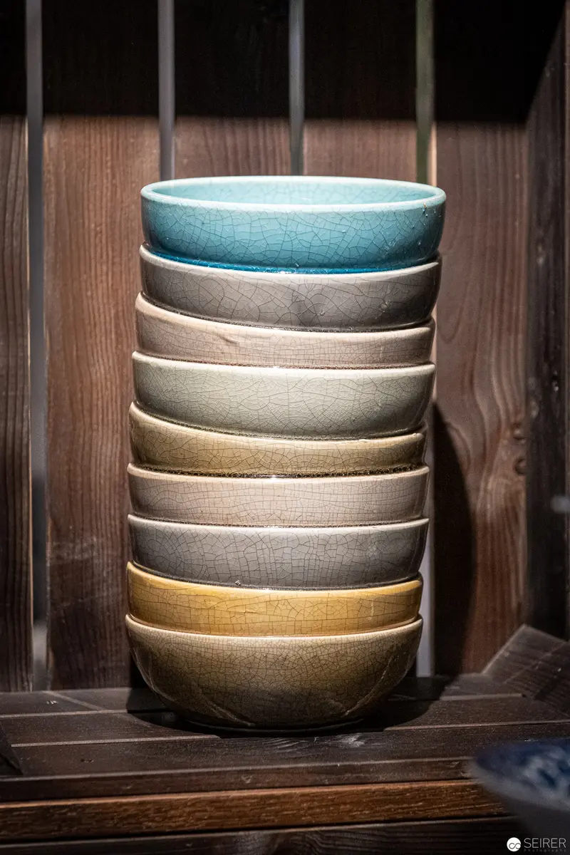 Stacked Ceramic Bowls in Muted Earth Tones on Wooden Background