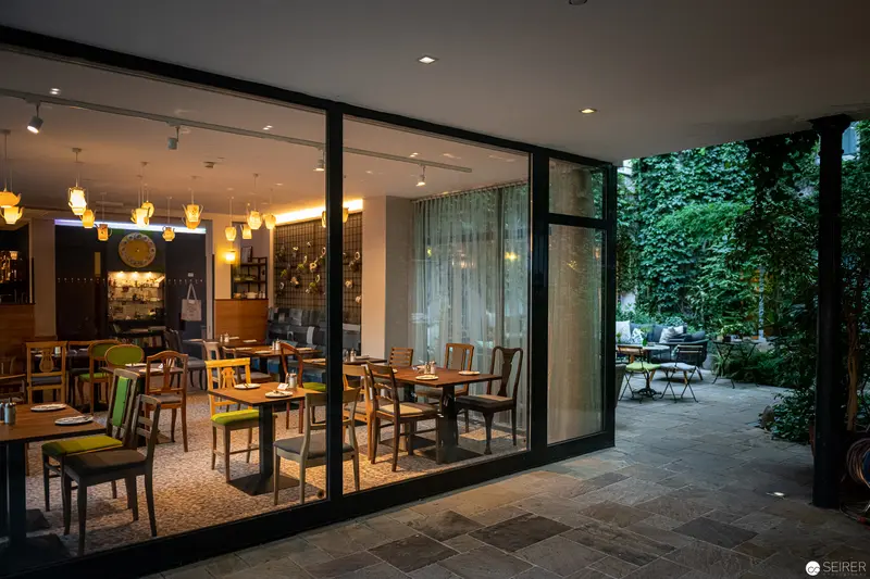 Minimalist Restaurant Interior with Garden View at Stadthalle Hotel, Vienna