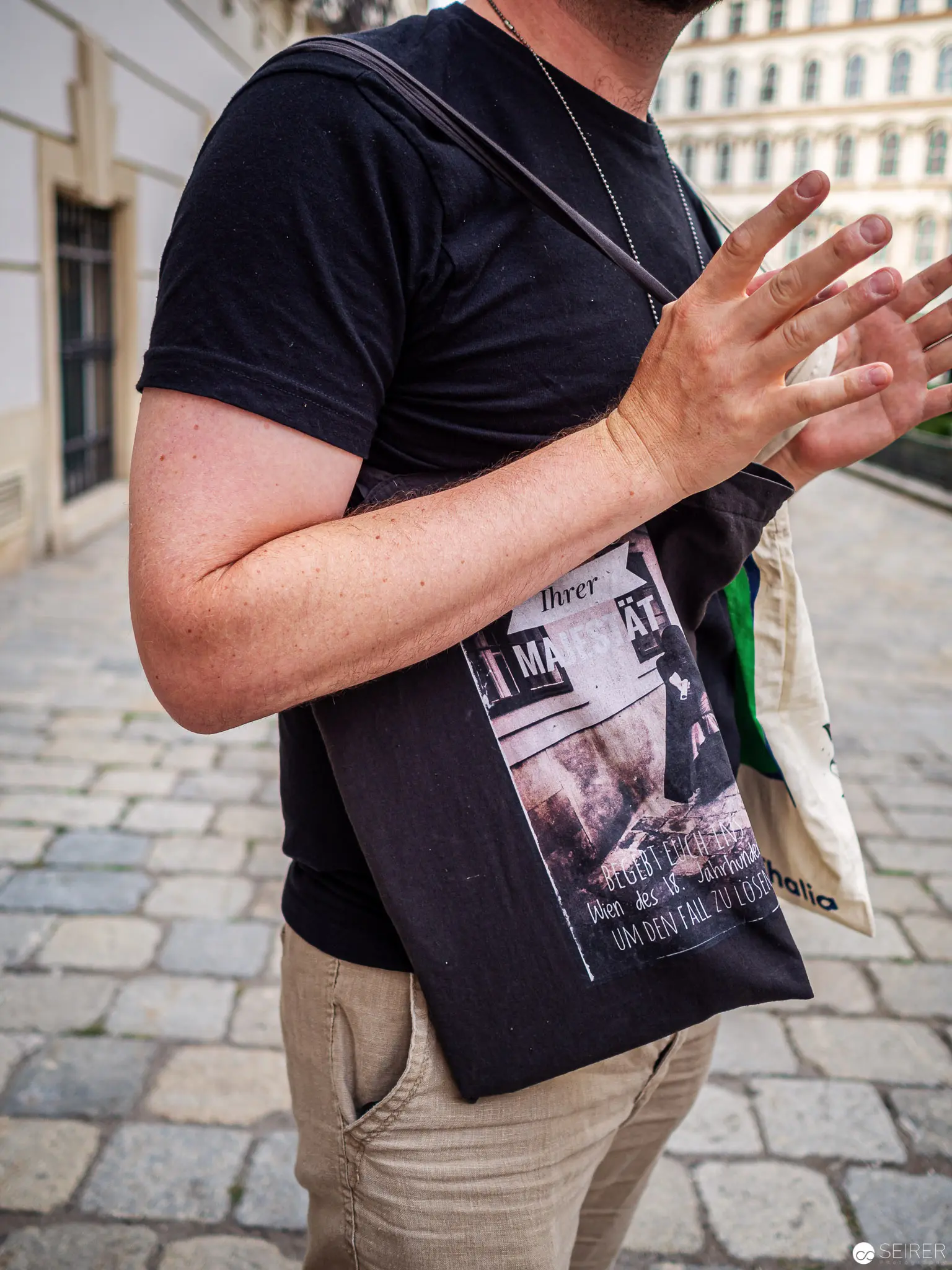 Urban Street Scene with Graphic T-Shirt and Gestural Hand Movement