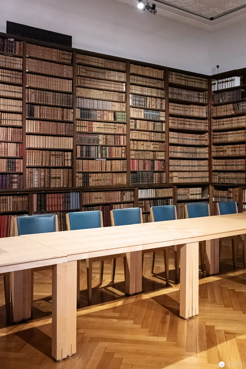 Monumental Library Interior with Modern Study Table and Blue Chairs