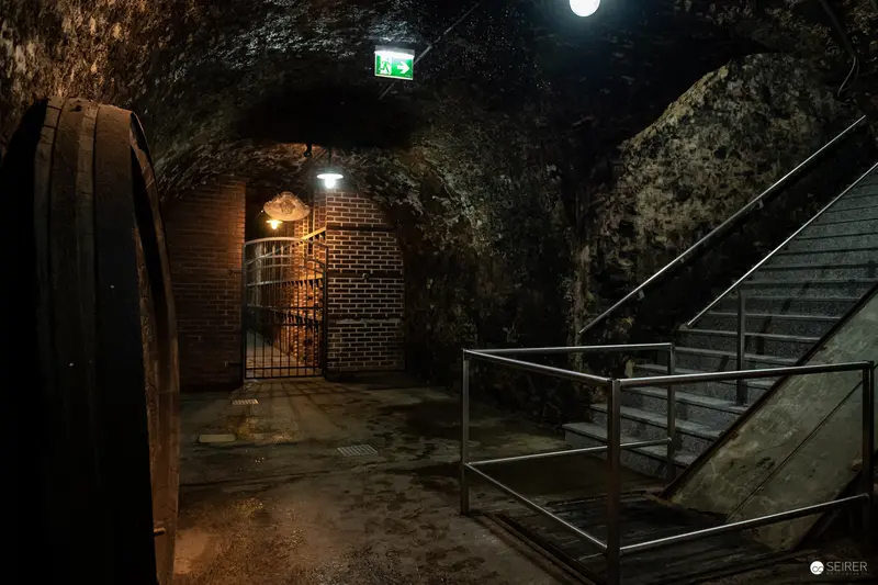 Underground Passageway with Illuminated Exit Sign and Stone Walls