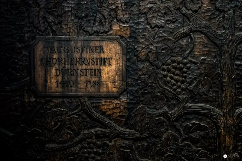 Augustinian Monastery Memorial Plaque on Textured Dark Wooden Surface