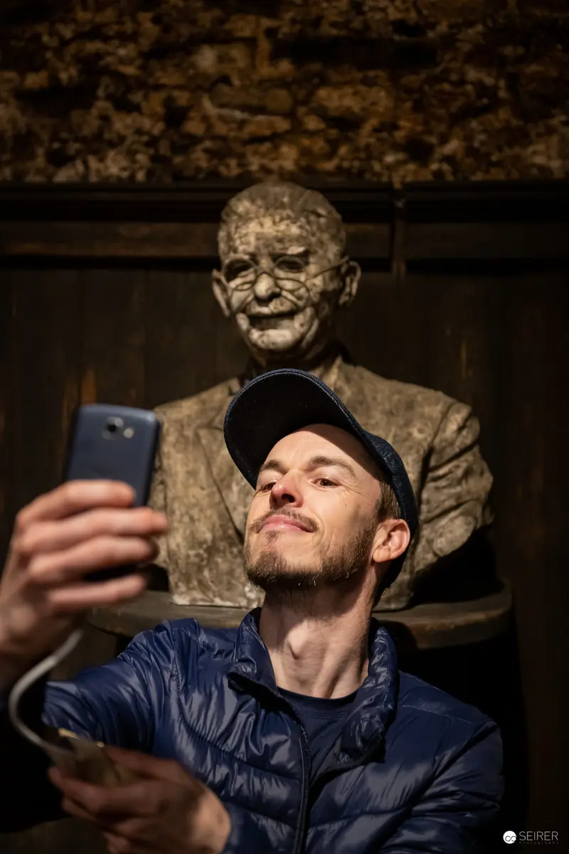 Behind-the-Scenes Selfie with Sculptural Portrait at Historic Venue