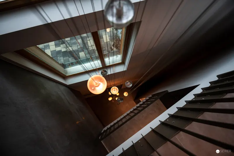 Architectural Interior with Suspended Lighting and Dramatic Staircase Perspective