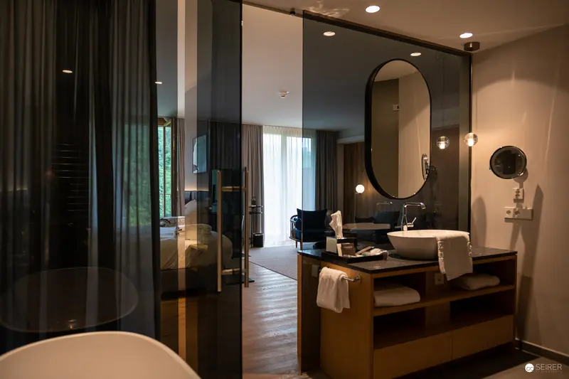 Contemporary Hotel Bathroom with Reflective Glass Partition and Minimalist Design