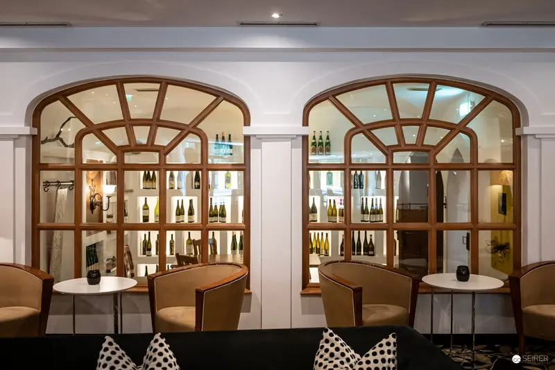 Elegant Wine Lounge with Arched Windows and Contemporary Seating