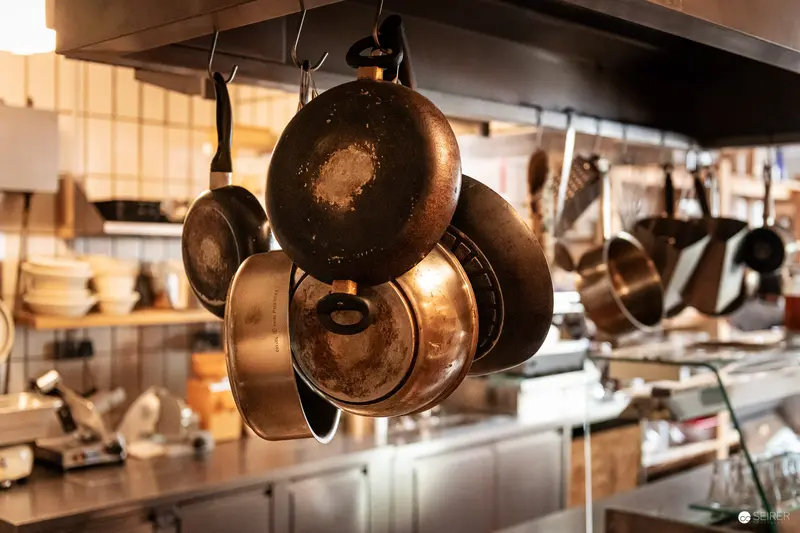 Vintage Copper Pans Hanging in Professional Kitchen Workspace
