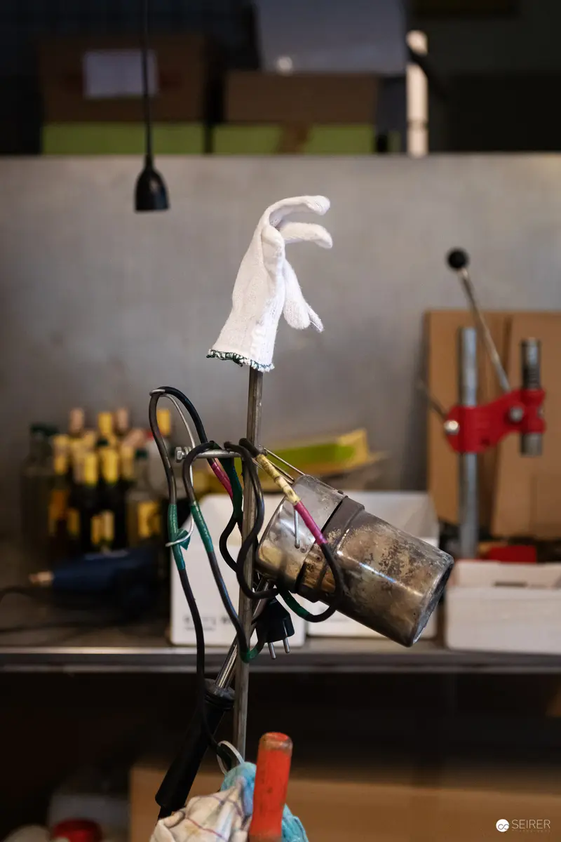 Workshop Illumination: Delicate White Glove on Intricate Metal Apparatus
