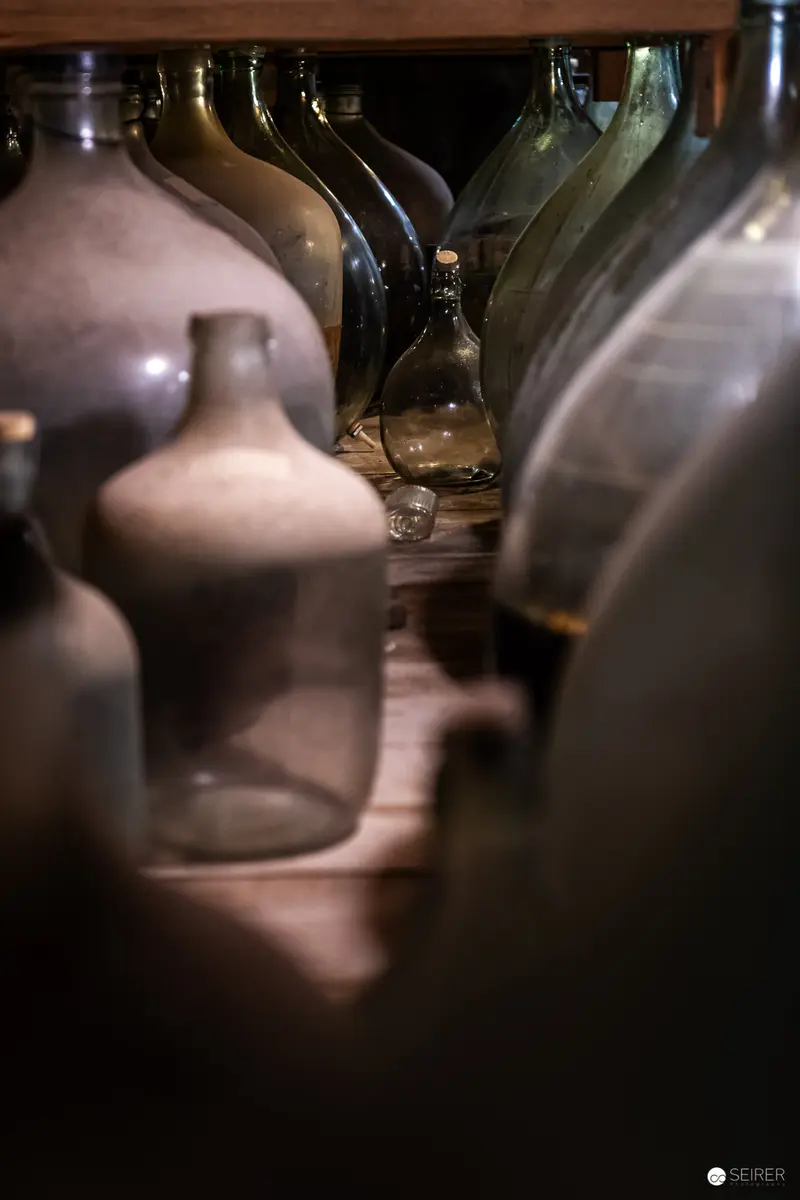 Gegenbauer Vinegar and Oil Factory: Blurred Glass Vessels in Shadowy Arrangement
