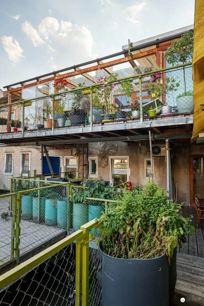 Urban Vertical Garden Balcony with Glass Panels and Potted Plants in Vienna