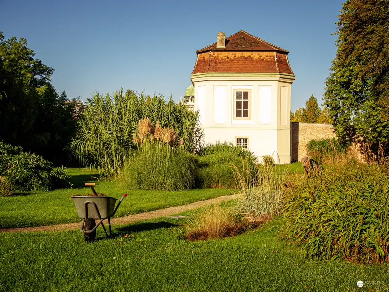 White Pavilion in Botanical Garden: Sunlit Landscape with Wheelbarrow