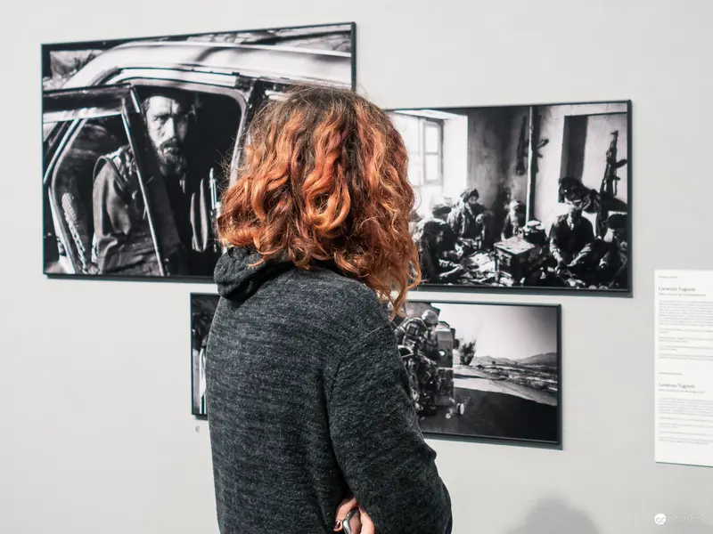 Museum Visitor Contemplates Black and White Photographic Exhibition of Social Documentary Work