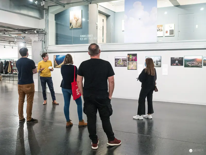 Gallery Visitors Viewing Photographic Exhibition in Contemporary Art Space