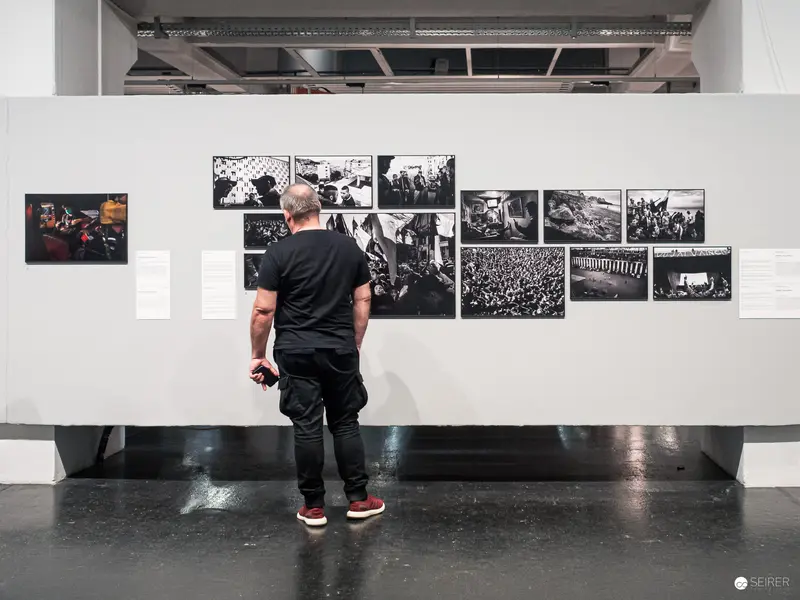 Anonymous Viewer Contemplating Black and White Documentary Photographic Exhibition