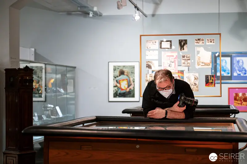 Curator Examining Display at Padhi Frieberger Fotokunst Exhibition, Westlicht