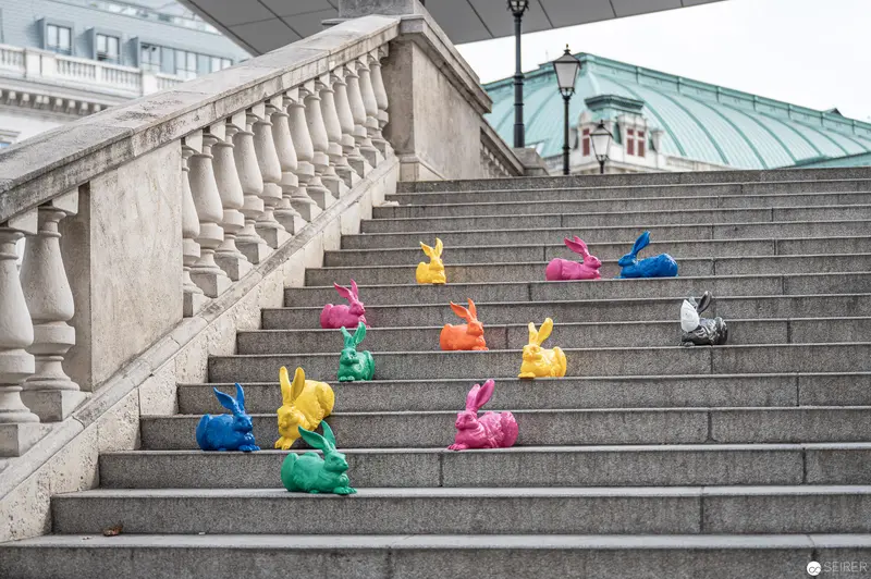Colorful Ceramic Rabbits Arranged on Monumental Stone Staircase in Urban Setting
