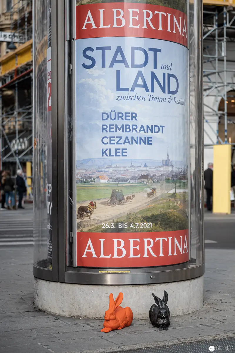 Albertina Museum's Stadt und Land Exhibition Poster with Playful Ceramic Rabbit Sculptures