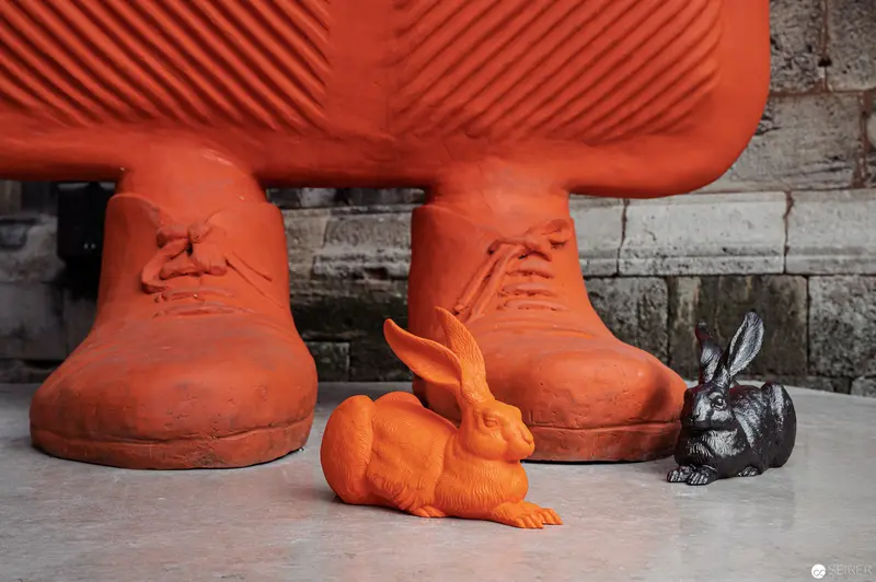 Comparative Rabbit Sculpture in Monochromatic Orange and Dark Tones